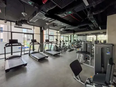 a gym with rows of treadmills and elliptical machines at Frank Porter - Prive Residence in Dubai