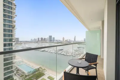 a balcony with a table and chairs and a view of a harbor at Silkhaus Tower with Private Beach and Skyline Views in Dubai