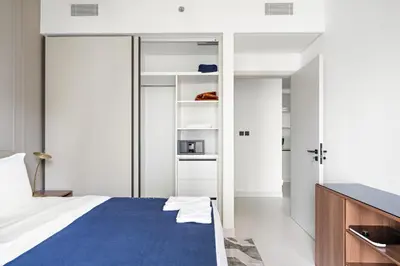 a bedroom with a bed with a blue blanket at Silkhaus Tower with Private Beach and Skyline Views in Dubai