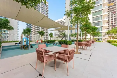a patio with tables and chairs and a playground at Silkhaus Tower with Private Beach and Skyline Views in Dubai