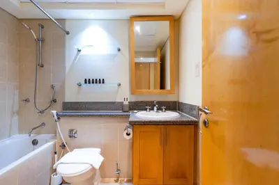 a bathroom with a toilet and a sink and a tub at Lux BnB I Turia Tower I Lake & Garden View in Dubai