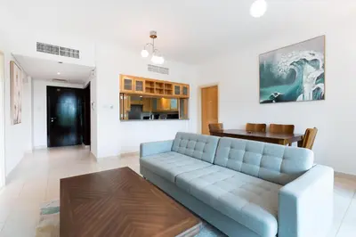 a living room with a blue couch and a table at Lux BnB I Turia Tower I Lake & Garden View in Dubai