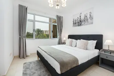 a bedroom with a large bed and a window at Lux BnB I Turia Tower I Lake & Garden View in Dubai