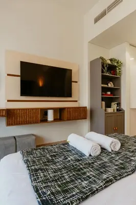 a bedroom with a bed with a flat screen tv at Modern Oasis: Spacious Studio Near Dubai Downtown in Dubai