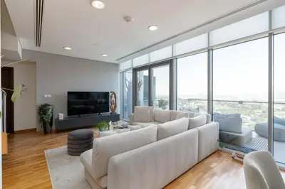 a living room with white furniture and glass windows at Burj Daman, DIFC Dubai - Mint Stay in Dubai