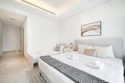 a white bedroom with a large bed and a couch at 2BR with Sea View & Terrace in Dubai