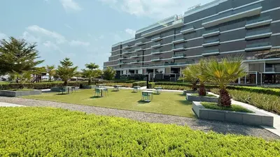 a park with tables and chairs in front of a building at 2BR with Sea View & Terrace in Dubai