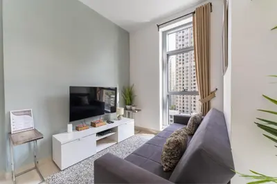 a living room with a couch and a tv at HAVN - Studio Unit in Claren Tower, Downtown Dubai in Dubai