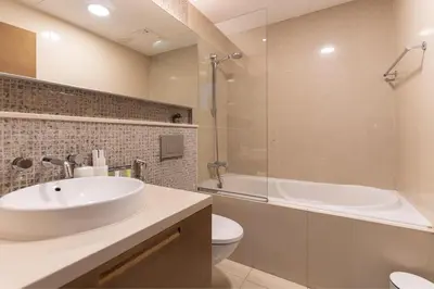 a bathroom with a sink and a tub and a toilet at HAVN - Studio Unit in Claren Tower, Downtown Dubai in Dubai