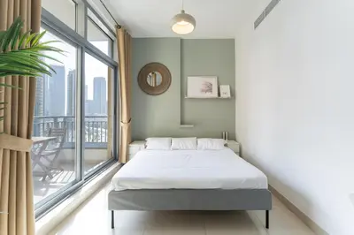 a bedroom with a bed and a large window at HAVN - Studio Unit in Claren Tower, Downtown Dubai in Dubai