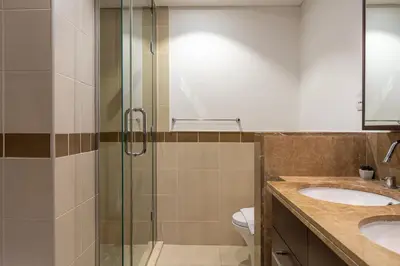 a bathroom with two sinks and a glass shower at Central 1BR with Downtown Fountain Views in Dubai