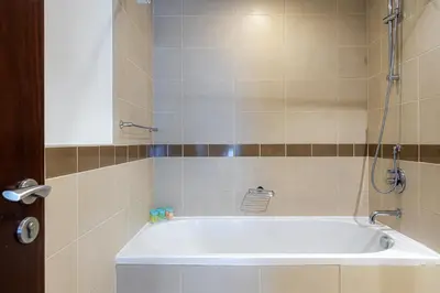 a white tub in a bathroom with a mirror at Central 1BR with Downtown Fountain Views in Dubai