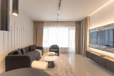 a living room with a couch and a tv at Central 1BR with Downtown Fountain Views in Dubai