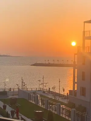 a view of the ocean at sunset with a pier at les voiles in Dubai