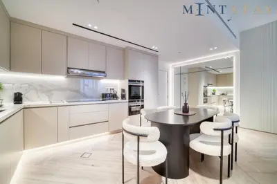 a kitchen with a table and some white cabinets at Silverene Tower B, Dubai Marina - Mint Stay in Dubai