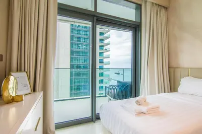 a bedroom with a bed and a large window at Privet Beach 2BR in Dubai Marina in Dubai