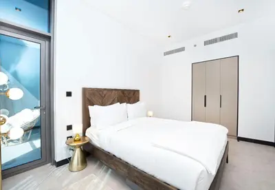 a white bedroom with a bed and a window at EasyGo - Northside Tower 2 Canal View in Dubai