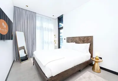 a bedroom with a white bed and a large window at EasyGo - Northside Tower 2 Canal View in Dubai