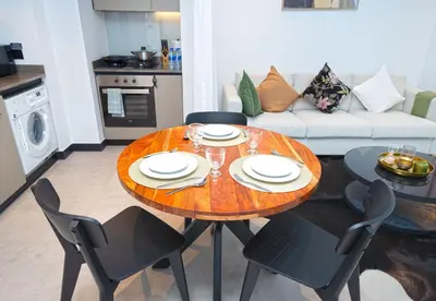 a dining table and chairs in a living room at EasyGo - Northside Tower 2 Canal View in Dubai