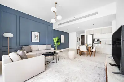 a living room with a white couch and a blue wall at Silkhaus Sea & Palm View 1BDR at Marina Vista in Dubai