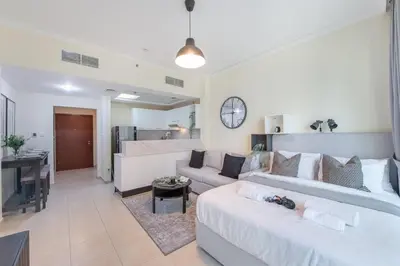 a living room with two white couches and a couch at HAVN - Studio in Downtown, Near Dubai Mall in Dubai