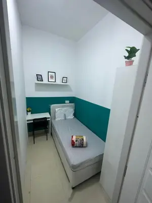 a small bedroom with a bed and a desk at Stop Over Partition Room in Al Barsha 1 Near Mashreq Metro in Dubai