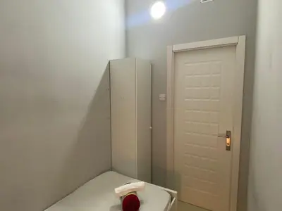 a white bathroom with a toilet and a door at Stop Over Partition Room in Al Barsha 1 Near Mashreq Metro in Dubai