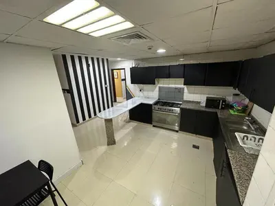 a kitchen with black and white cabinets and a stove at Stop Over Partition Room in Al Barsha 1 Near Mashreq Metro in Dubai