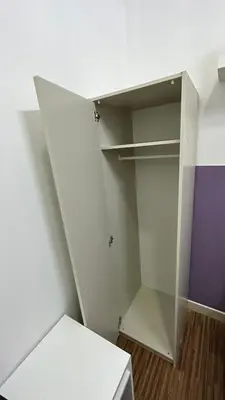 a white cabinet in a room with a purple wall at Partition Room 5 Mins to Mashreq Metro in Dubai