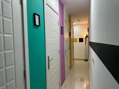 a hallway with several doors with different colors at Partition Room 5 Mins to Mashreq Metro in Dubai