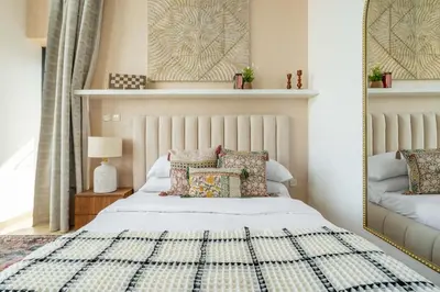 a bedroom with a bed with a mirror and pillows at GuestReady Holiday Homes - Arabian Elegance in JVC in Dubai
