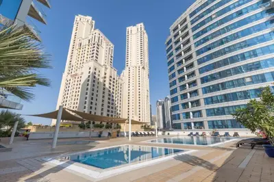 a pool in the middle of a city with tall buildings at HAVN -1 Bedroom Apartment with Dubai Marina View in Dubai