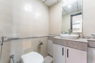 a bathroom with a toilet sink and a mirror at HAVN -1 Bedroom Unit in Dubai Marina, Marina View in Dubai