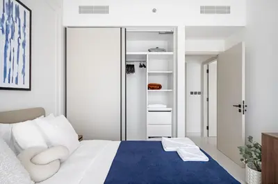 a bedroom with a king sized bed with a blue rug at Silkhaus Full Marina View 2BDR in Unique New Tower in Dubai