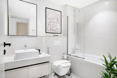a white bathroom with a sink and a toilet at Silkhaus Full Marina View 2BDR in Unique New Tower in Dubai