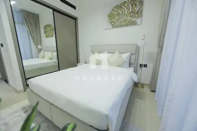 a bedroom with a large white bed and a mirror at Modern 1br Jvc Balcony & Free Parking Pool in Dubai