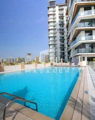 a swimming pool in front of a building at Modern 1br Jvc Balcony & Free Parking Pool in Dubai