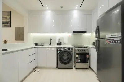 a kitchen with white cabinets and a washer and dryer at Modern 1br Jvc Balcony & Free Parking Pool in Dubai
