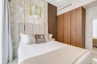 a bedroom with a large white bed and a chandelier at GlobalStay Reva & Vera Residences Business Bay Apartments in Dubai