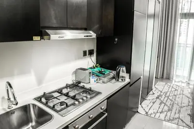 a kitchen with a stove top oven next to a sink at Perfect Studio Apartment Near to Metro Station in Dubai