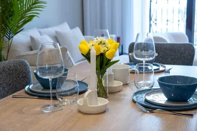 a dining room table with yellow flowers in a vase at Veluxa - Fantastic 1 Bed - in Jumeirah Golf Estate! in Dubai