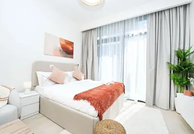 a white bedroom with a bed and a large window at EasyGo - Azizi Riviera 15 Community View in Dubai