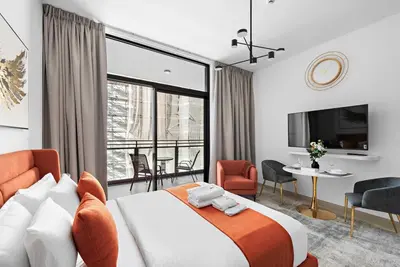 a hotel room with a bed and a table and chairs at StoneTree - Brand new Studio in Mohammed Bin Rashid City in Dubai