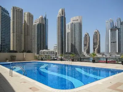a large swimming pool in front of a city skyline at HAVN - 2 Bedroom in Dubai Marina, 10min to Metro in Dubai