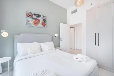 a white bedroom with a white bed and a table at HAVN - 2 Bedroom in Dubai Marina, 10min to Metro in Dubai