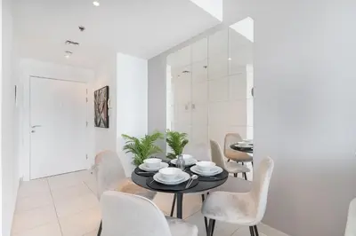 a dining room with a black table and chairs at HAVN - 2 Bedroom in Dubai Marina, 10min to Metro in Dubai