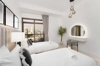 a white room with two beds and a window at Beautiful 2 Bedroom Retreat in the Heart of JBR in Dubai