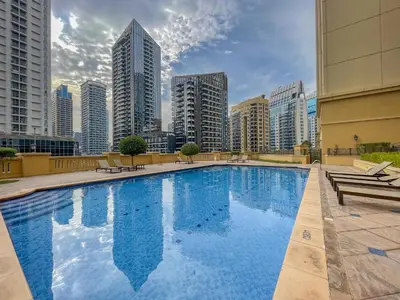 a large swimming pool in a city with tall buildings at Beautiful 2 Bedroom Retreat in the Heart of JBR in Dubai