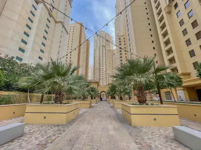 a street in a city with palm trees and buildings at Beautiful 2 Bedroom Retreat in the Heart of JBR in Dubai
