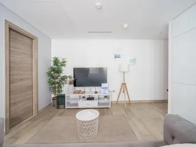a living room with a tv and a couch at HAVN - 2 Bedroom Apartment with Dubai Marina View in Dubai
